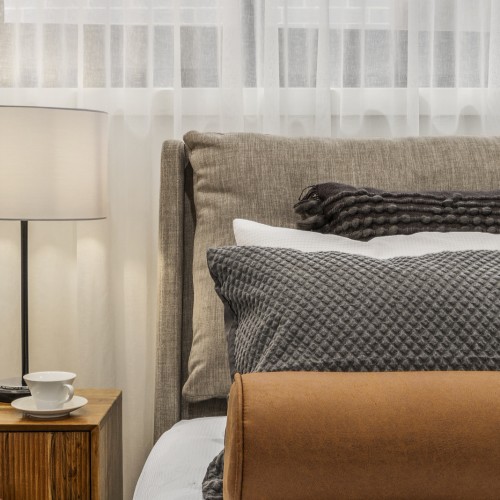 tan, grey, white pillow on bed